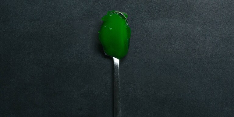 A spoon with green jelly 