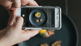 Some taking a photo of A plate of perfectly presented gourmet food