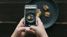 A chef taking a photo of perfectly presented food