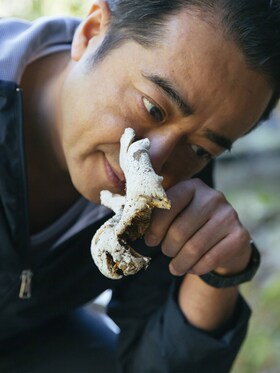 Hisato smelling a freshly picked oyster mushroom
