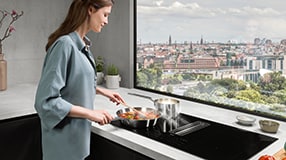 Woman standing by hob