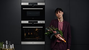 Man holding flowers in front of oven